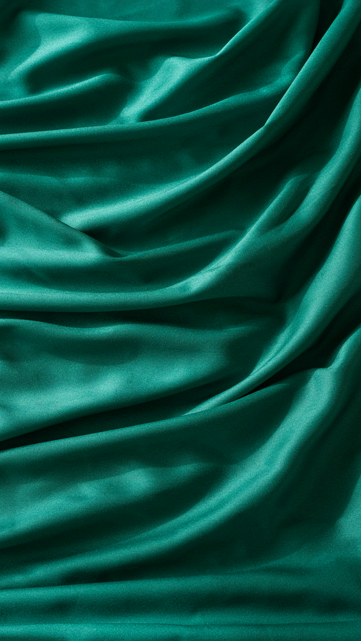 Heavy silk charmeuse fabric drapes in controlled folds, reflecting light.