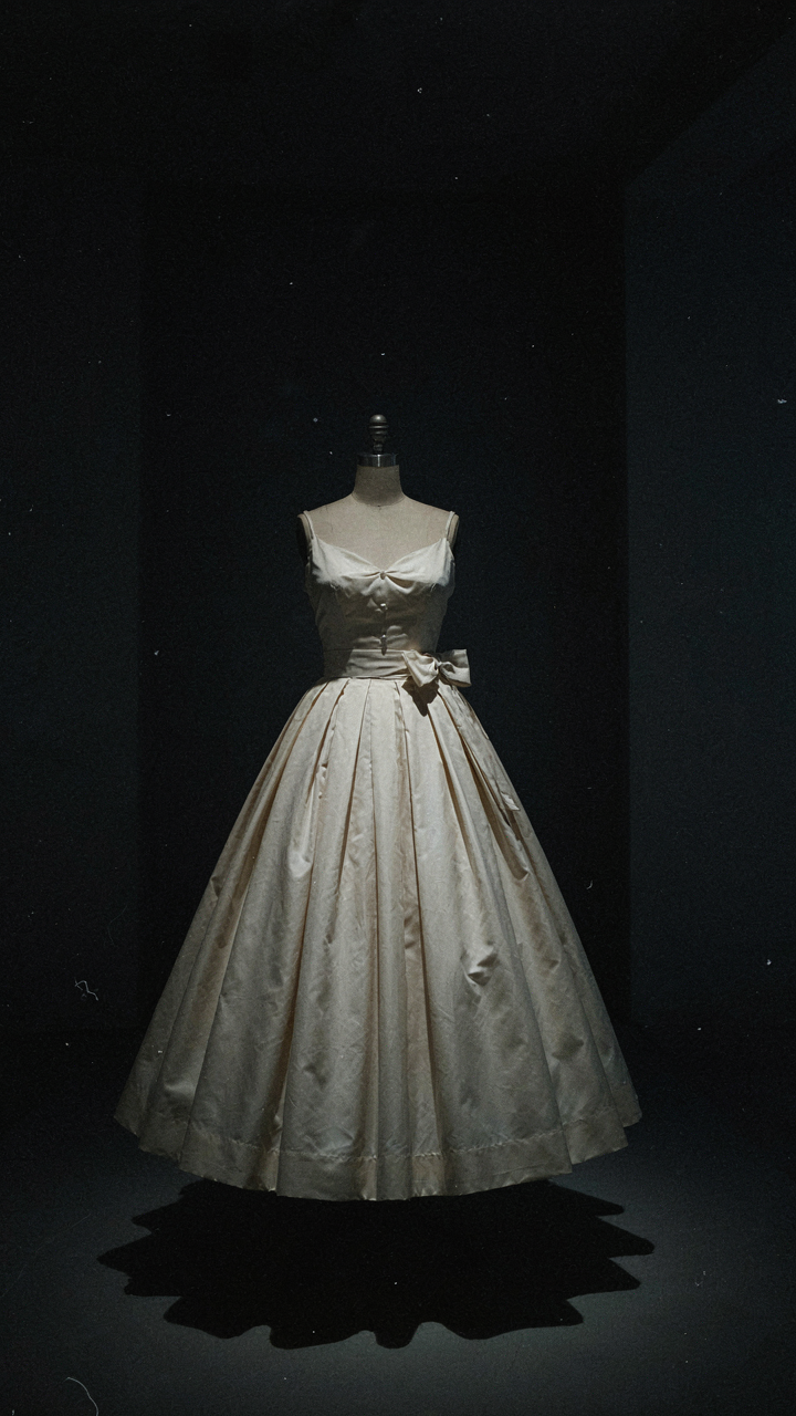 A 1950s dress on a mannequin, showing its structured, voluminous skirt.