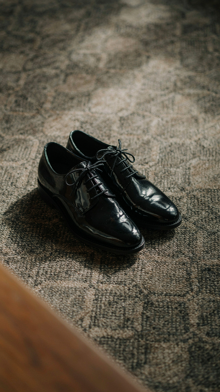 A pair of highly polished black formal shoes with sturdy soles.