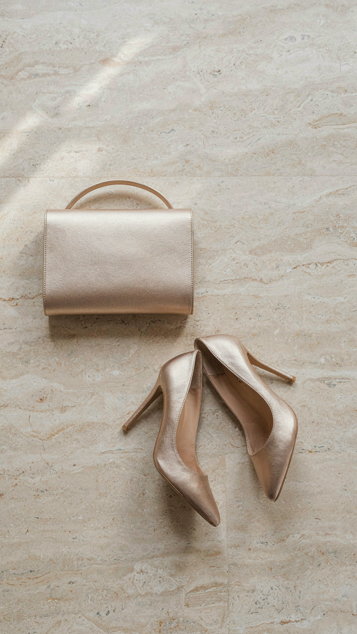 An elegant clutch bag next to a pair of classic stiletto heels.