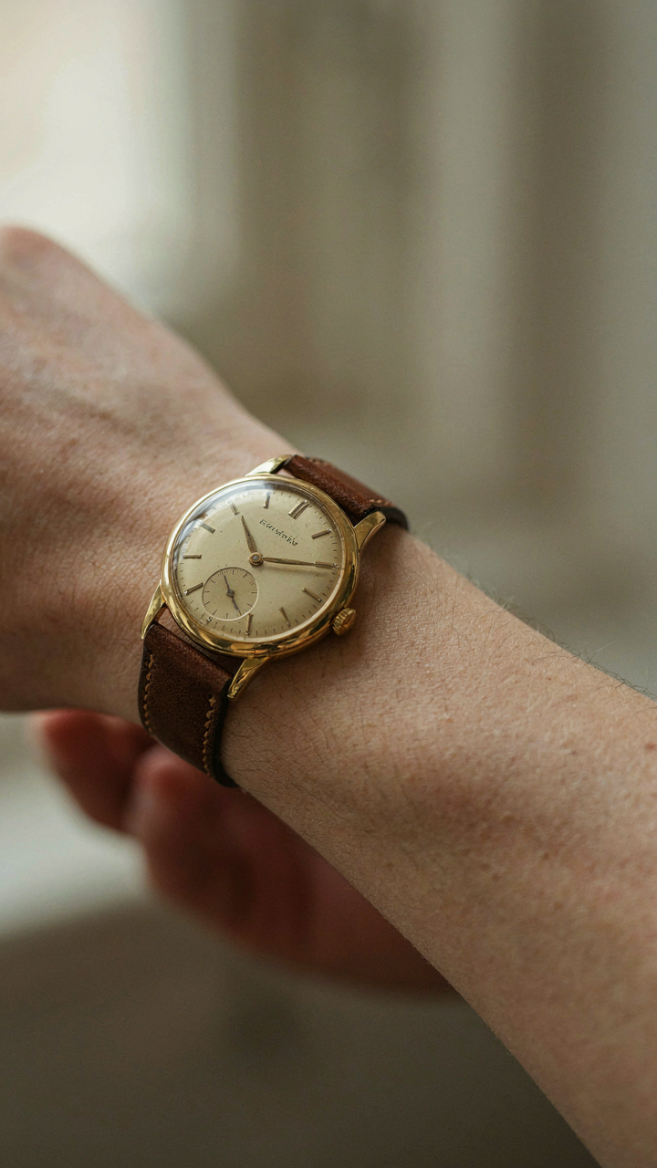 A close-up of a vintage watch on a person's wrist.
