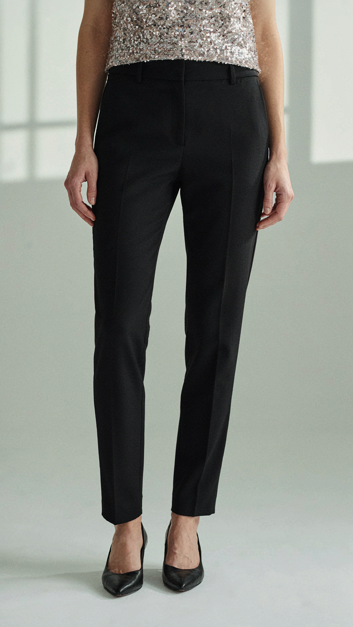 A sequin top paired with sleek, black tailored trousers.