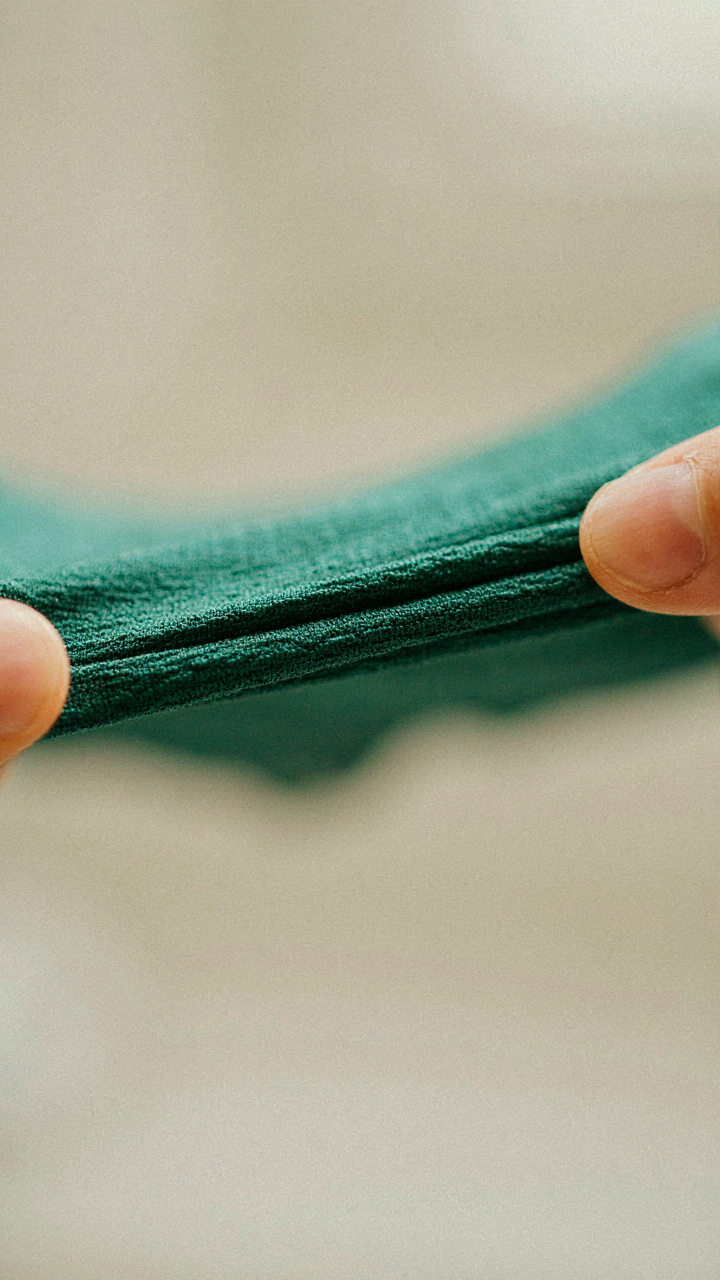 Close-up of crepe fabric being stretched, showing its texture.