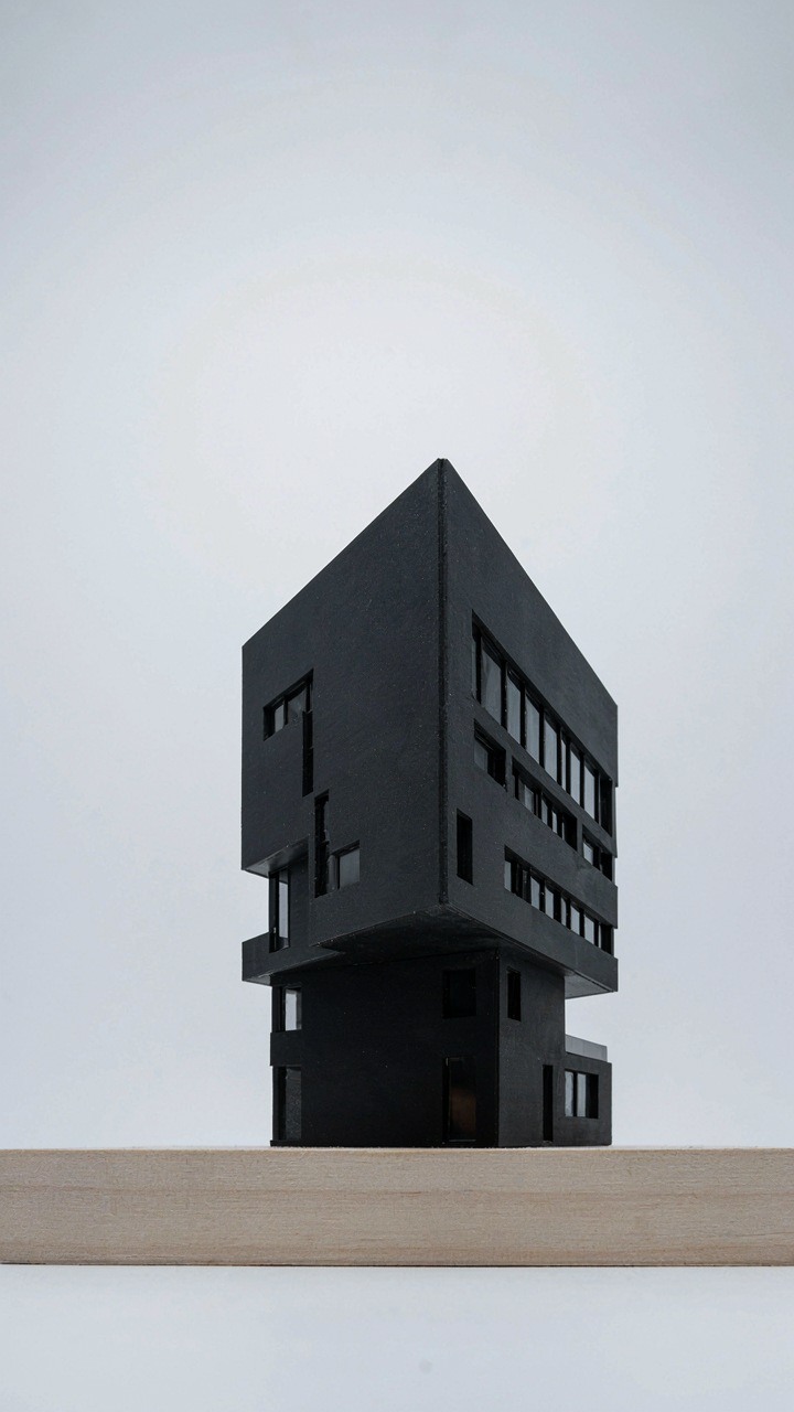 An architectural model of a black building with strong, clean lines.