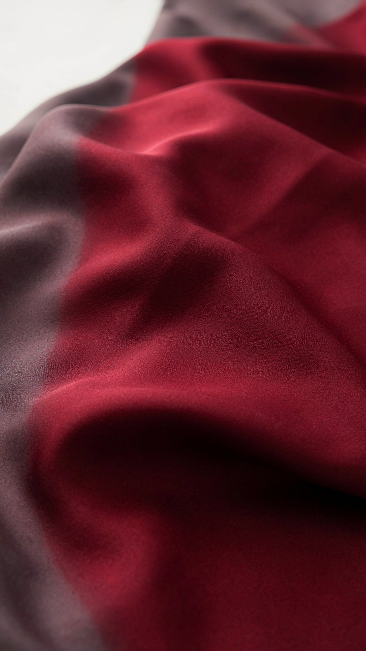 Rich burgundy silk fabric layered over a muted charcoal gray fabric.