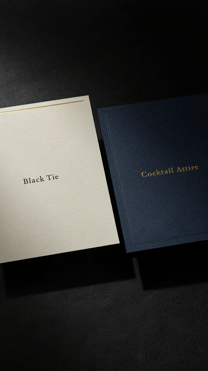 Close-up of two invitations showing 'Black Tie' and 'Cocktail Attire' dress codes.