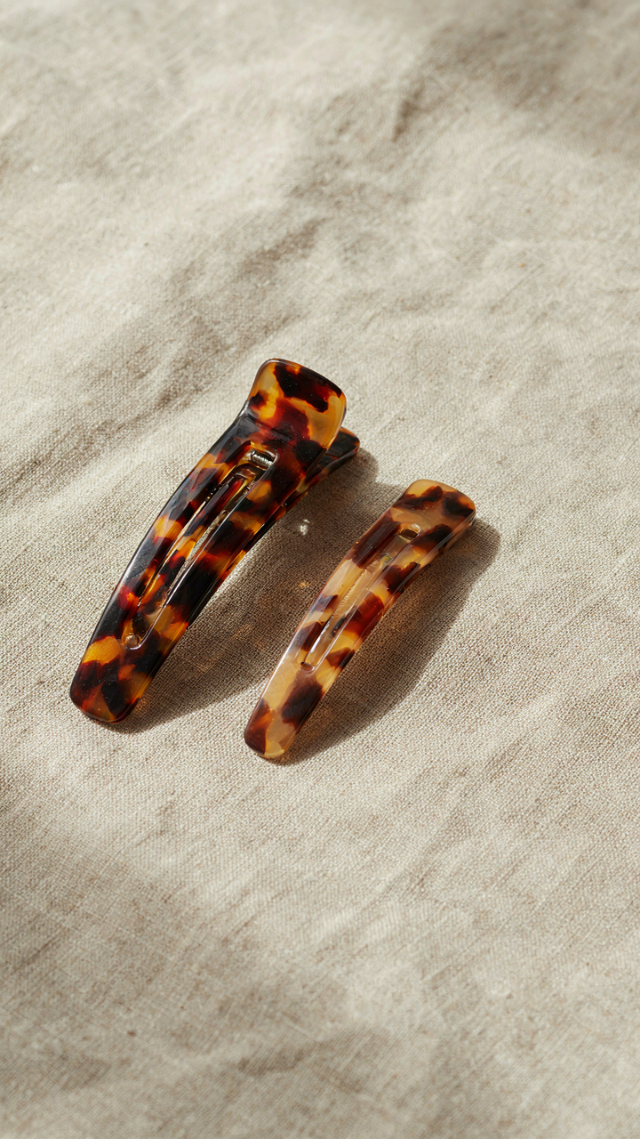 A beautiful tortoiseshell hair clip sits next to a plastic one.