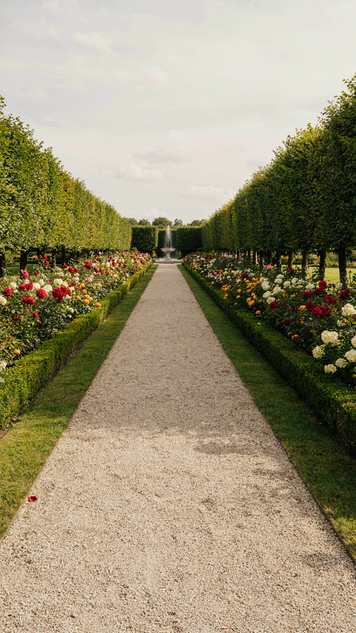 A meticulously manicured formal garden with symmetrical hedges and flower beds.