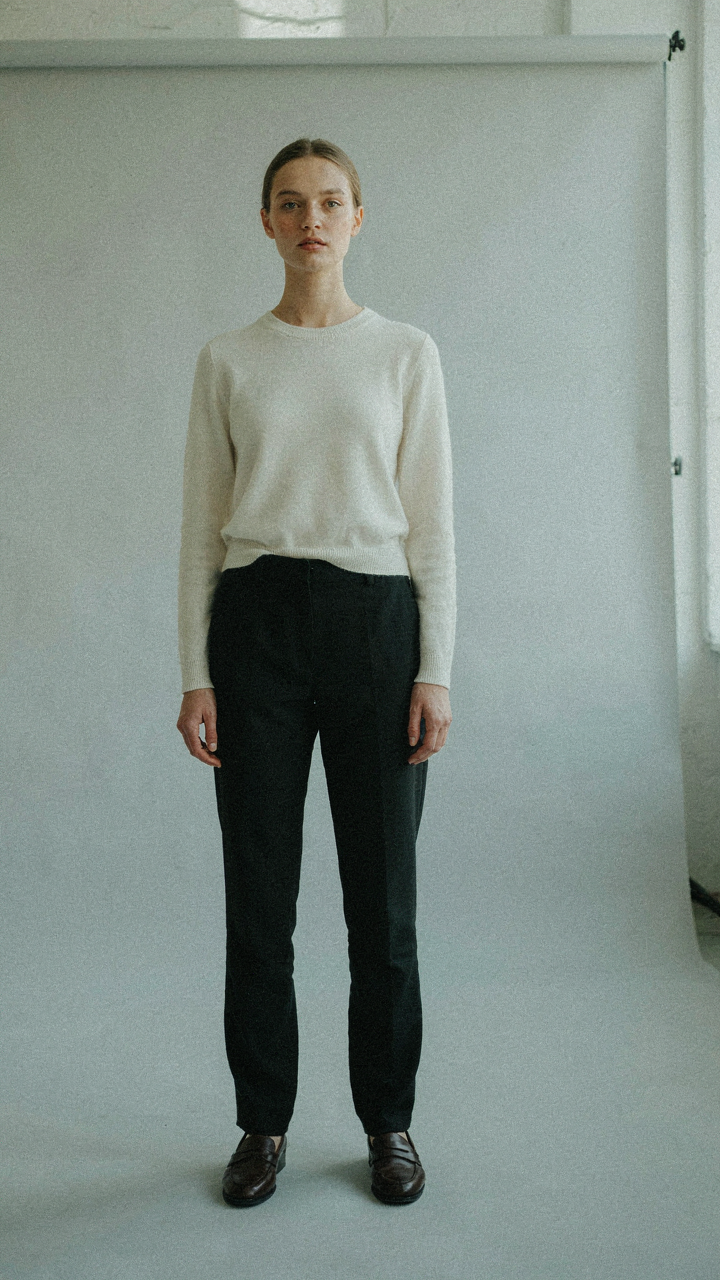 A person standing with impeccable posture and confident gaze.