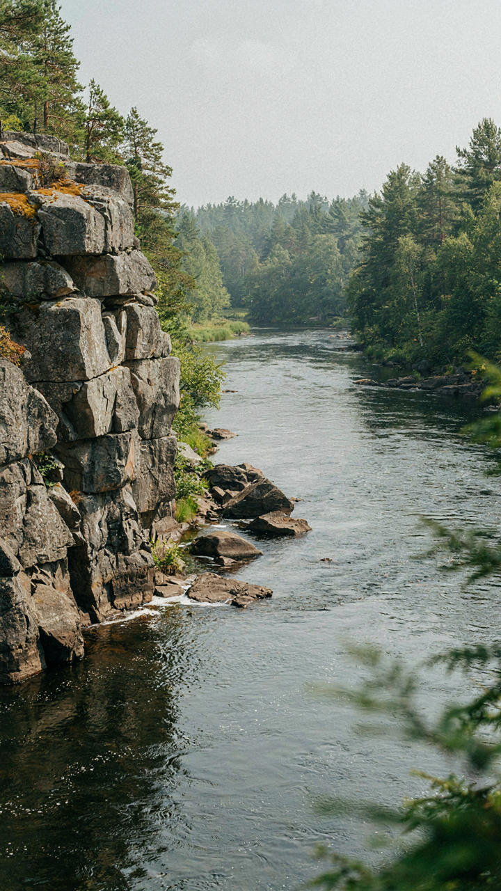 A rugged rock formation contrasts with a smooth, flowing river.