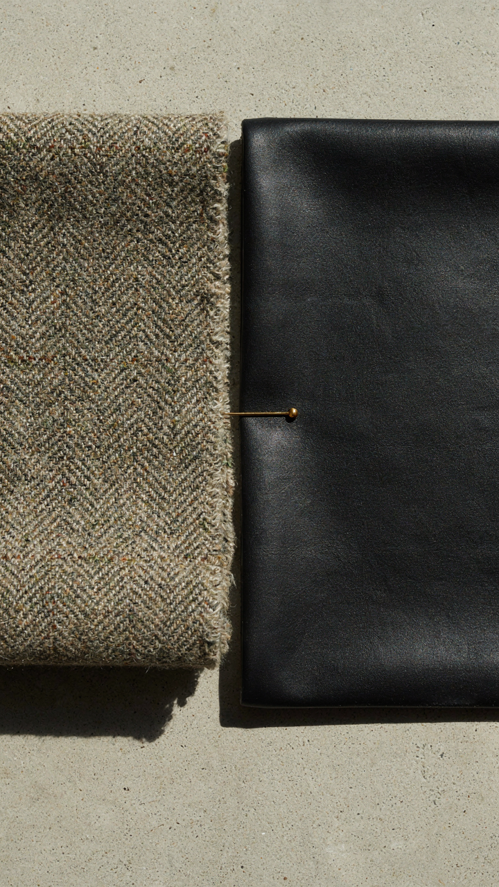 Rough tweed fabric sample next to a smooth, shiny black leather sample.