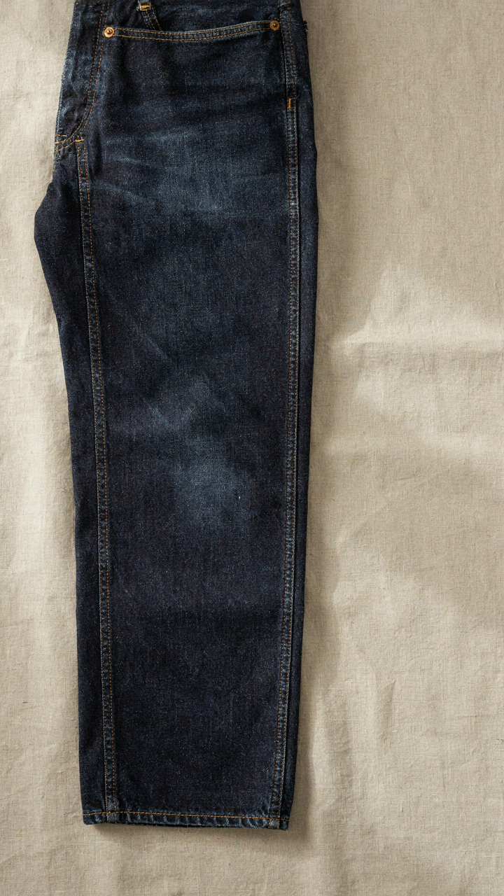 A close-up shows durable dark denim jeans with strong seams and tight stitching.