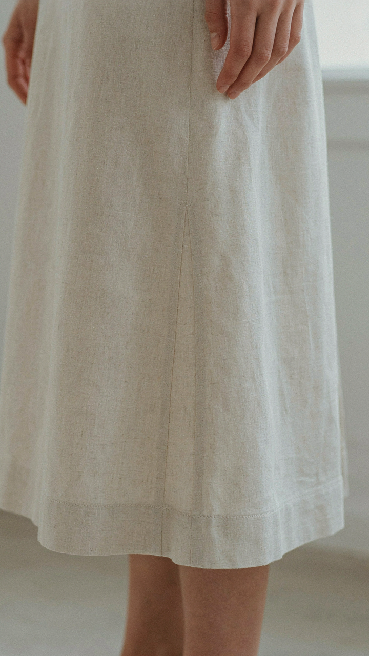 Close-up of a midi dress hem with visible French seams and stitching.