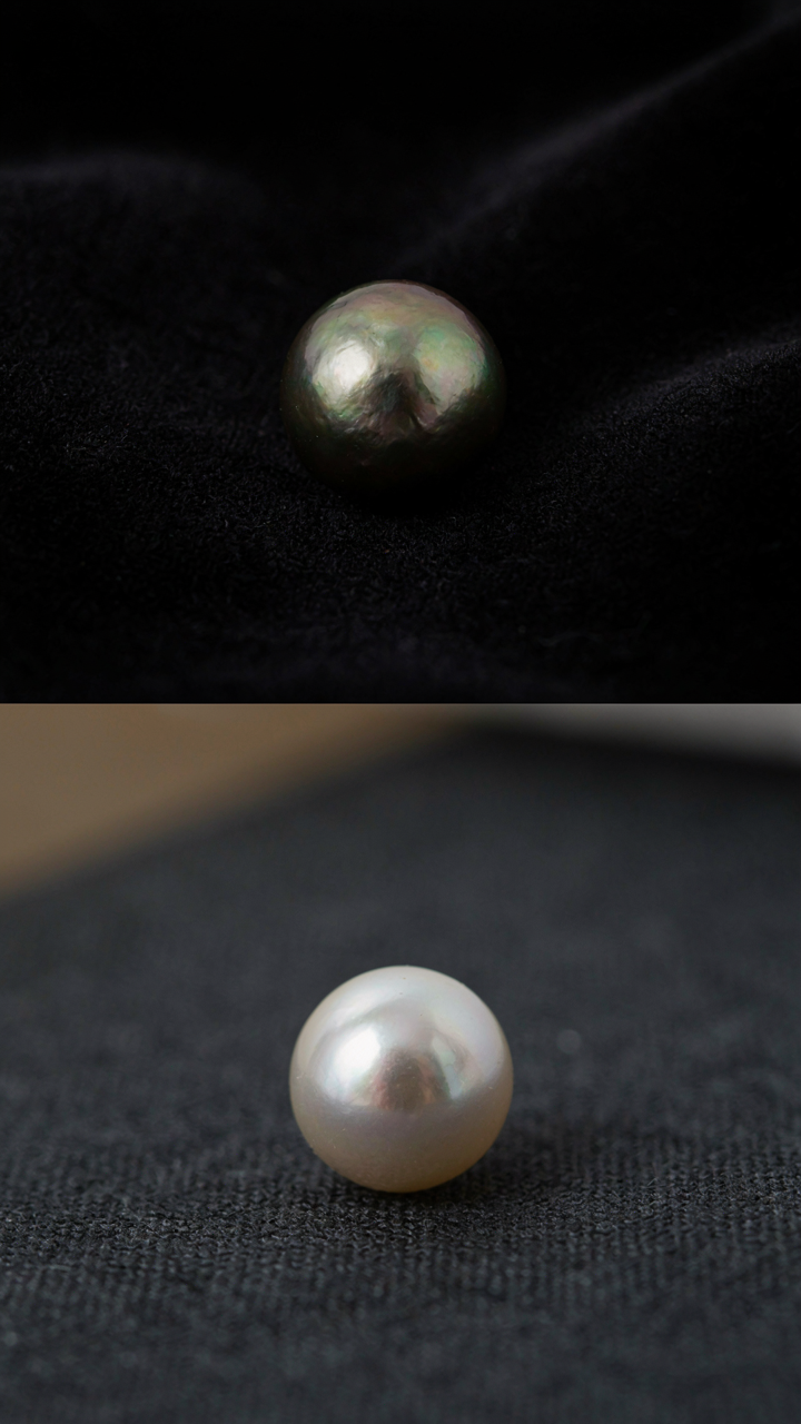 Warm and cool toned pearls rest on different shades of dark fabric.