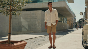 Person in a capsule wardrobe for hot climates, standing comfortably on a sunny city street.