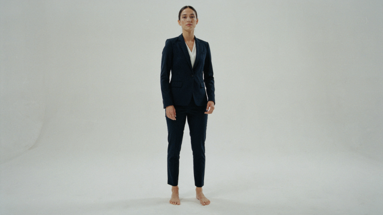 A petite woman in a perfectly tailored navy pantsuit, showcasing ideal fit.