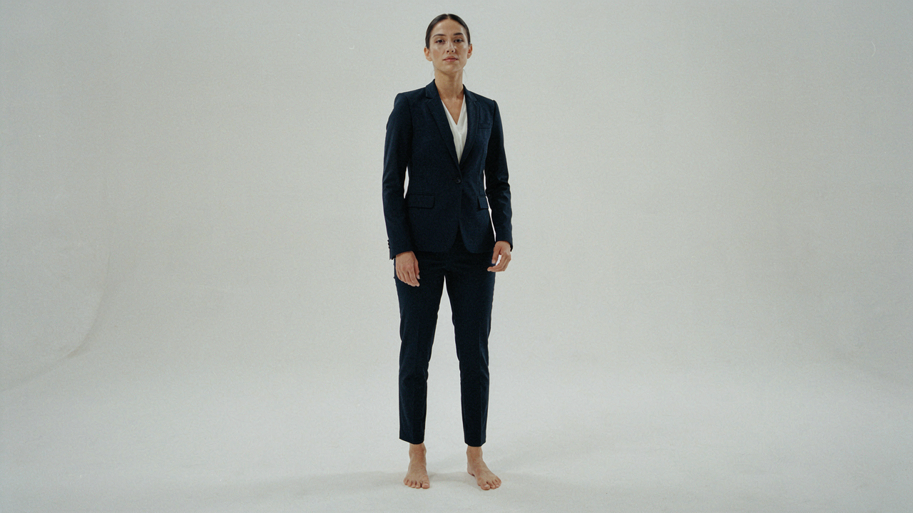 A petite woman in a perfectly tailored navy pantsuit, showcasing ideal fit.