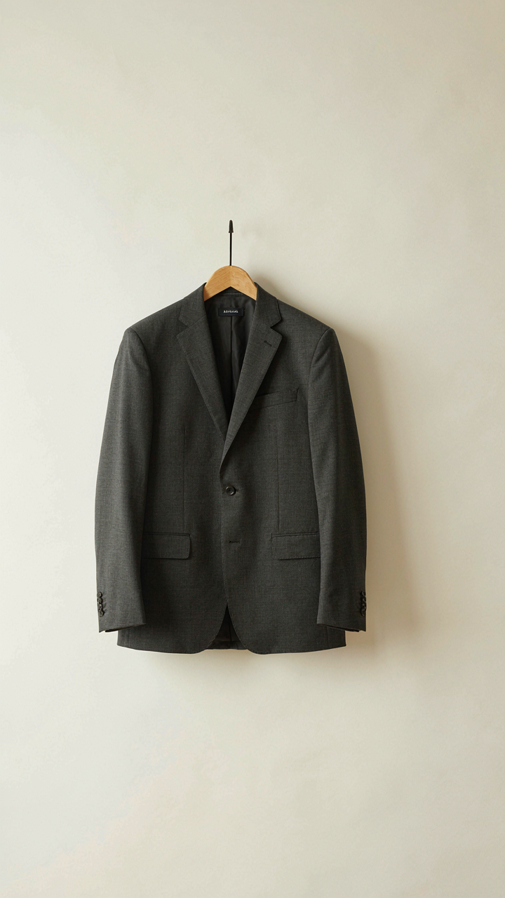 A well-tailored blazer hangs neatly in a minimalist closet space.