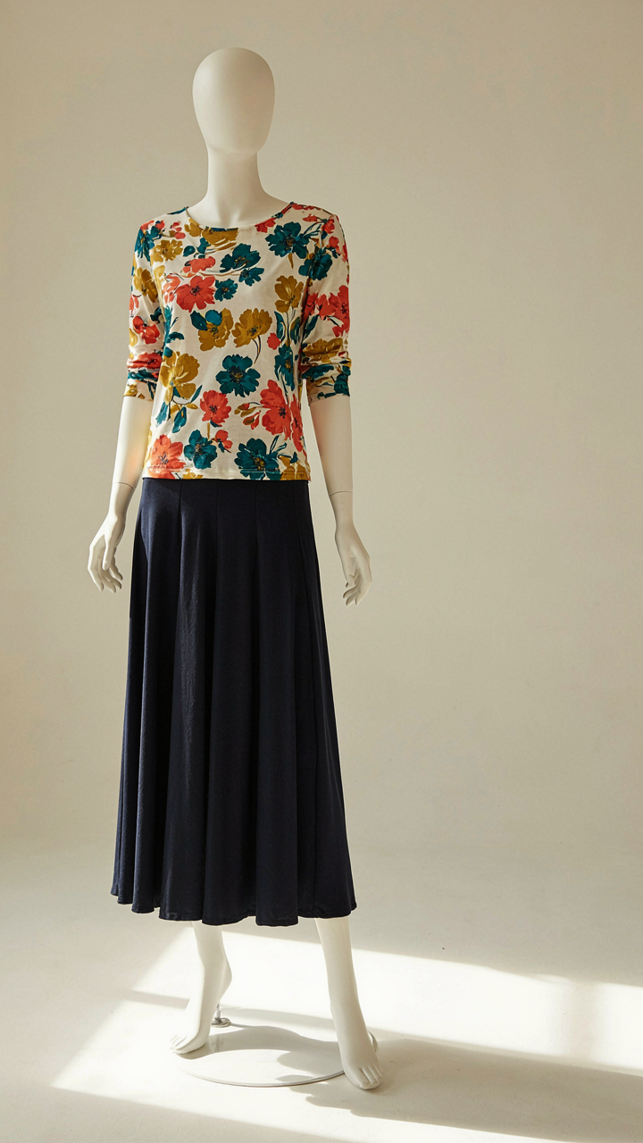 Dark navy long skirt on a mannequin paired with a bright, patterned blouse.