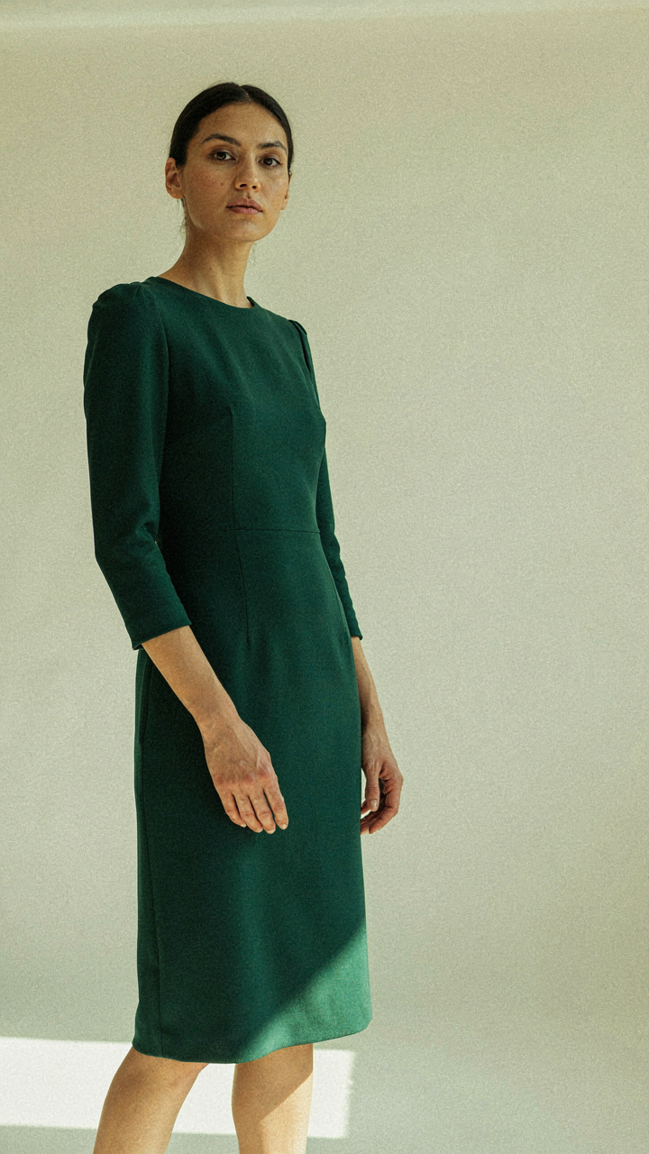 A deep emerald green tailored dress, showing its rich color.