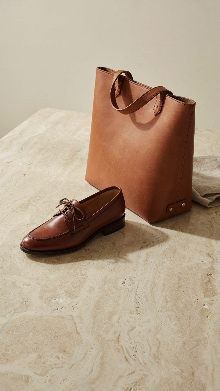 A well-maintained leather loafer and structured leather tote bag on a clean surface.