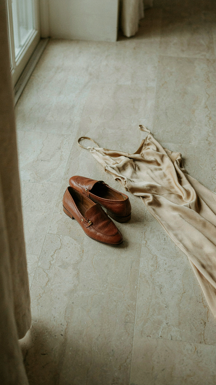 Burnished leather flat loafers next to a silk charmeuse gown.