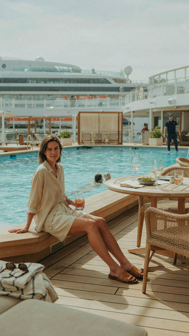 A woman in quick-dry clothes sits by a cruise ship pool, ready for multiple activities.