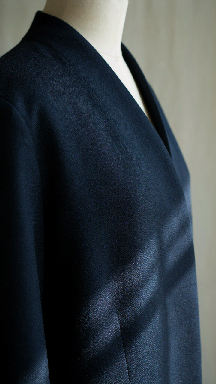 Close-up of luxurious wool barathea fabric draped on a mannequin.