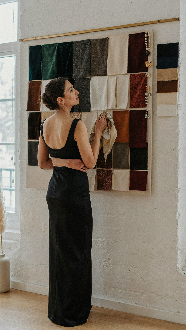 A woman in a black gown studies different mood boards about creative black tie attire.