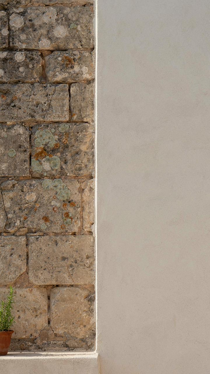 A textured stone wall next to a plain, smooth painted wall.
