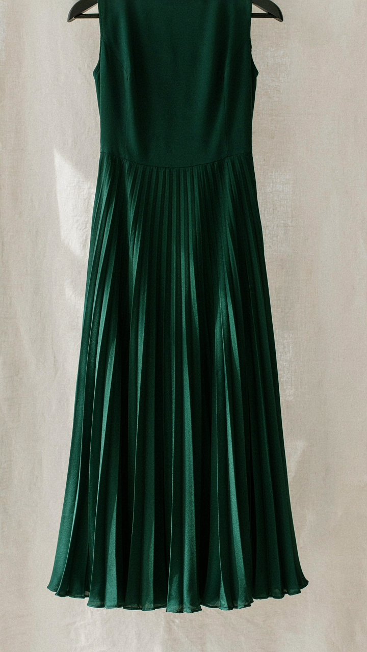 Close up of high quality fabric and stitching on a pleated midi dress.