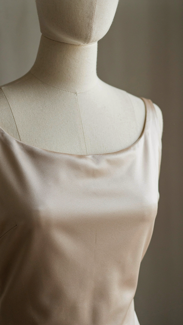 Luxurious silk charmeuse fabric draped smoothly on a mannequin's boat neck.