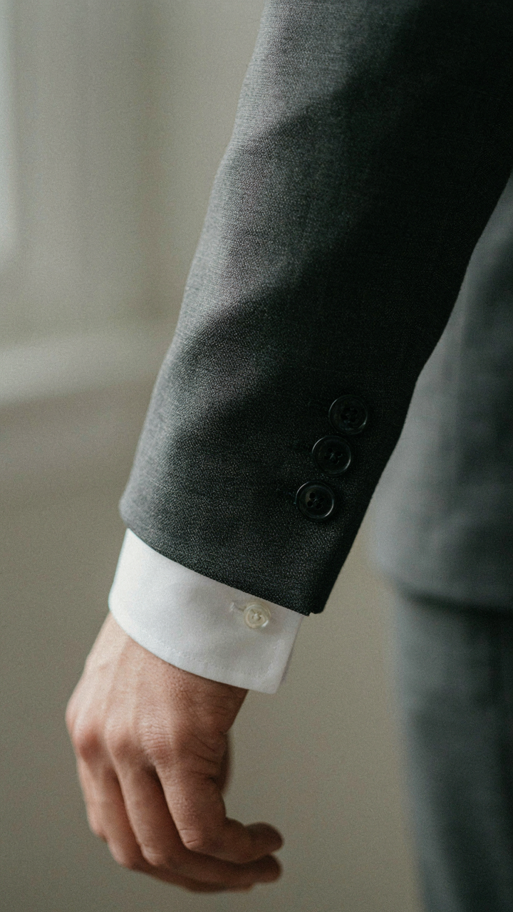 Close-up of a tailored suit sleeve and a crisp white dress shirt cuff.