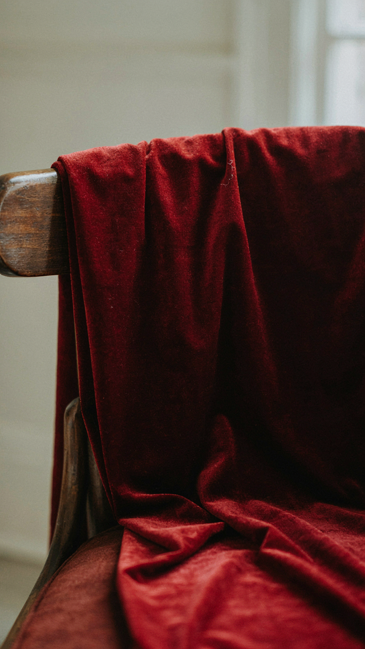 A close-up of rich velvet fabric draped over a chair.