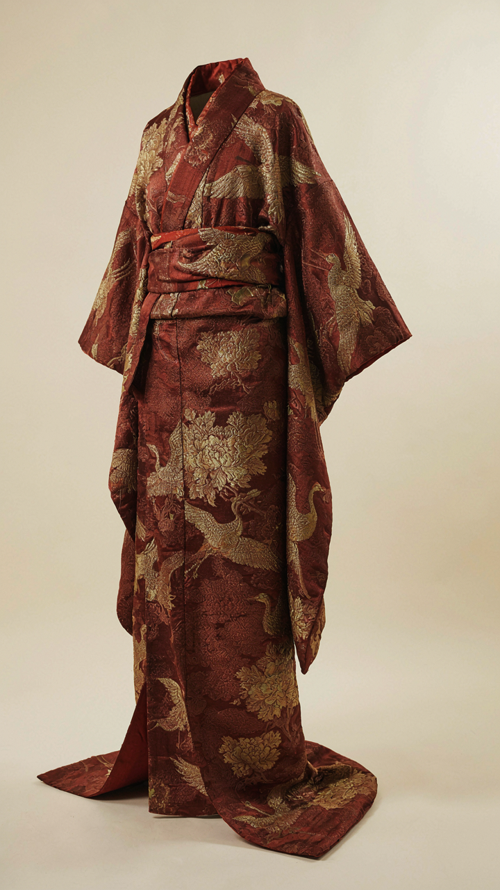A close-up of a floor-length kimono jacket made from heavy brocade fabric.
