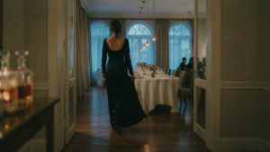 A woman in a fine dining dress code outfit walks into a luxurious restaurant.