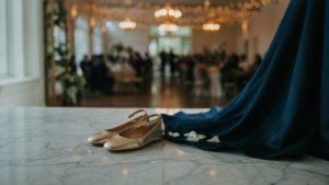 Elegant gold flats for wedding guest outfit next to a formal navy blue gown.