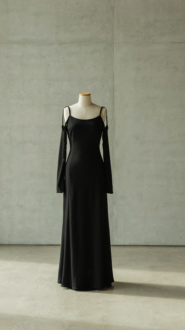 A sleek, floor-length matte black crepe maxi dress on a mannequin.