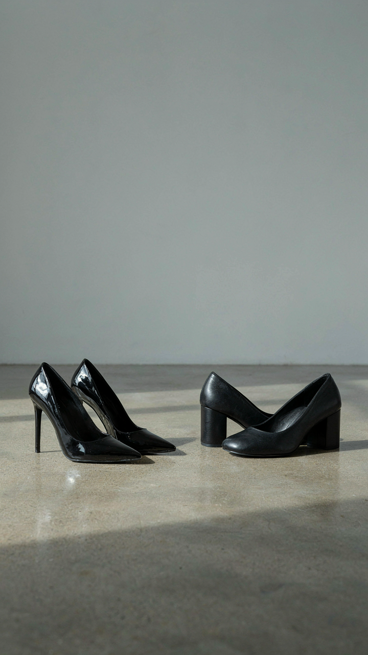 A pair of stiletto heels sits next to a pair of block heels.