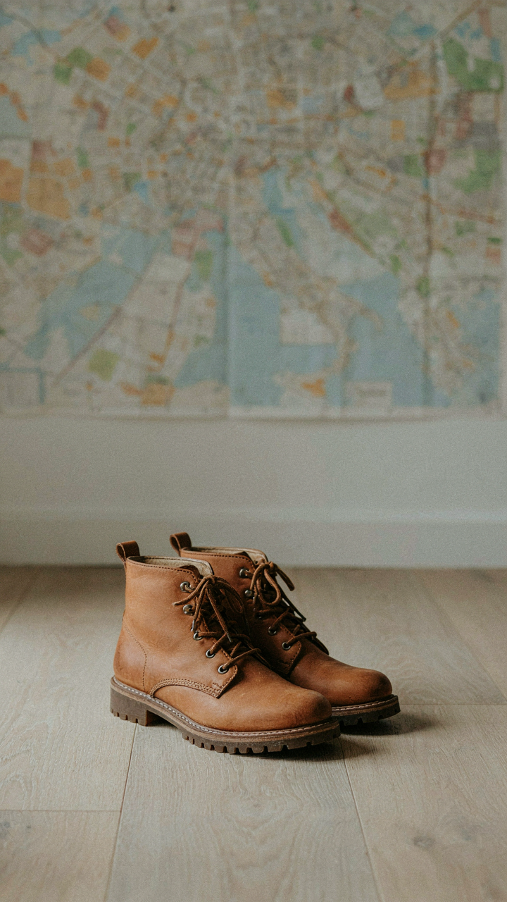 Waterproof leather ankle boots with rubber soles sit on a wooden floor.