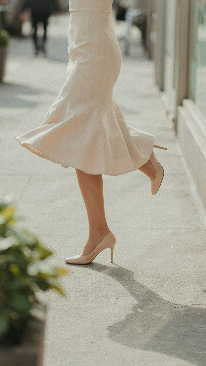 Woman's legs in a knee-length fit and flare dress while high-stepping.