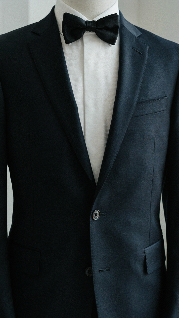 A close-up of a tailored tuxedo jacket and crisp white shirt.