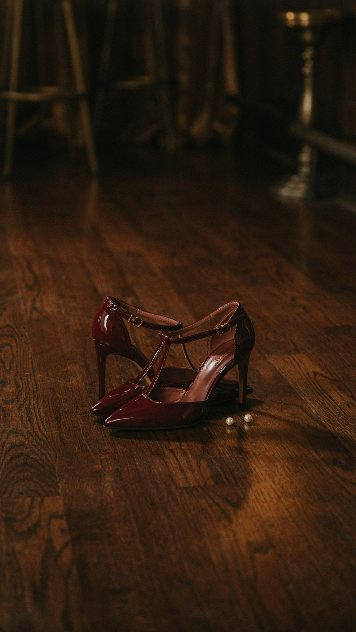 Elegant T-strap heels, perfect for a speakeasy party outfit, on a wooden floor.
