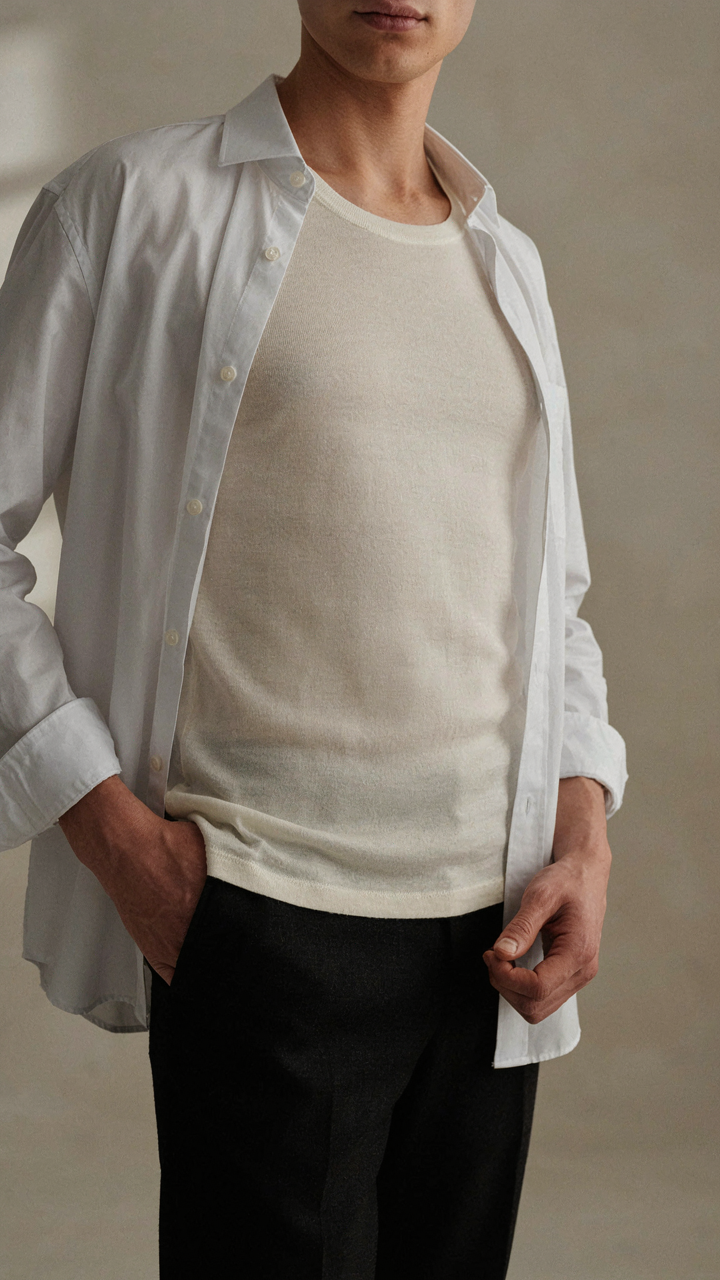 A person wears a snug merino wool base layer under a dress shirt.