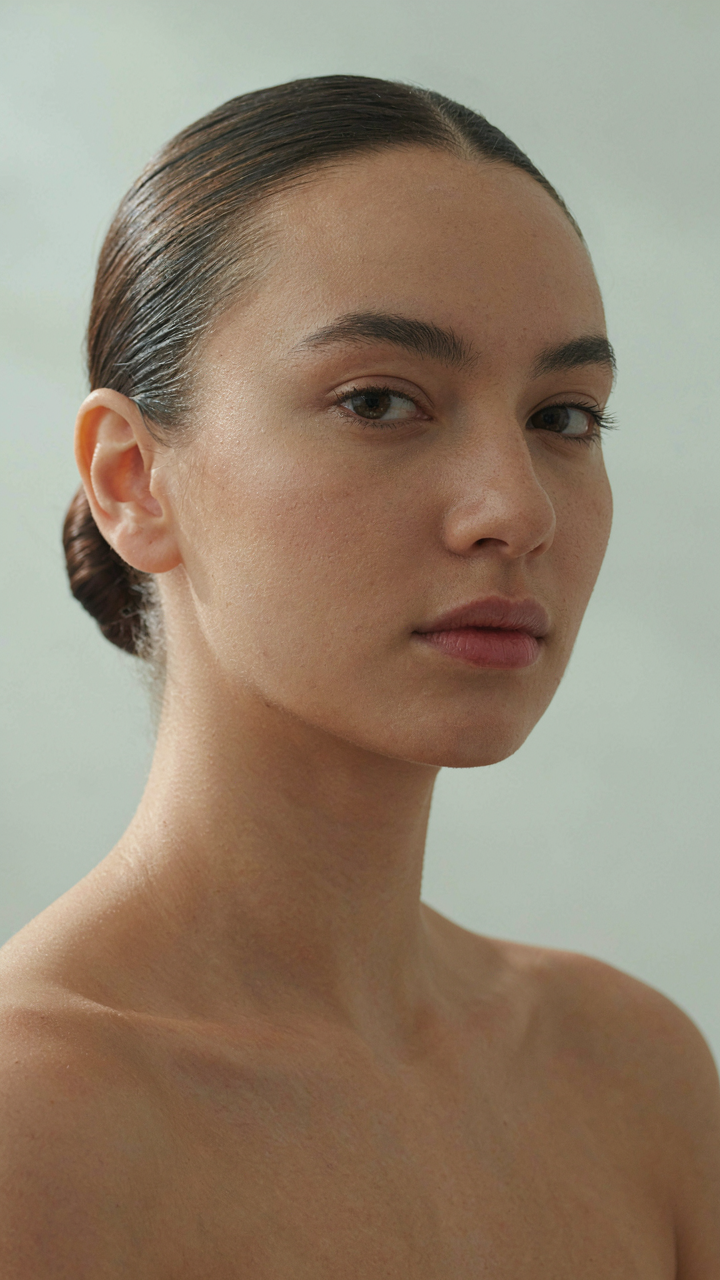 A woman's hair is styled in a sleek low bun, resisting humidity.