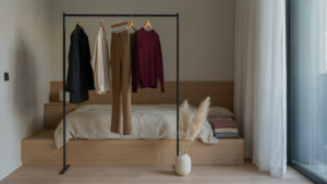 A carefully curated holiday party capsule wardrobe hangs on a rack in a bright room.