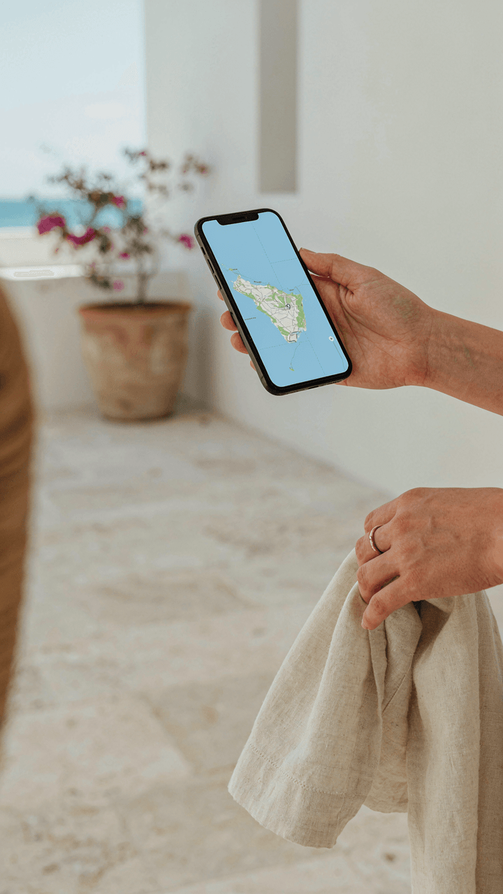 A person's hand holds a phone displaying a map of Barbados.