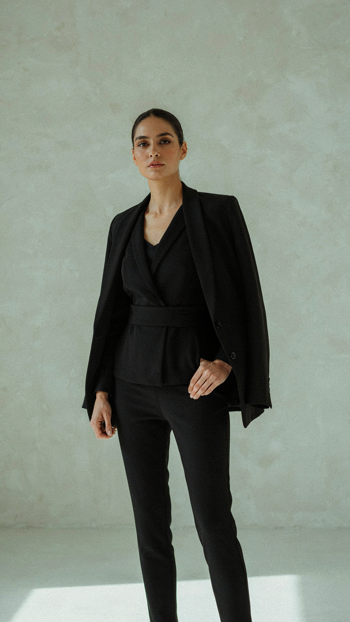 A black jumpsuit with a structured blazer shows intentional layering.
