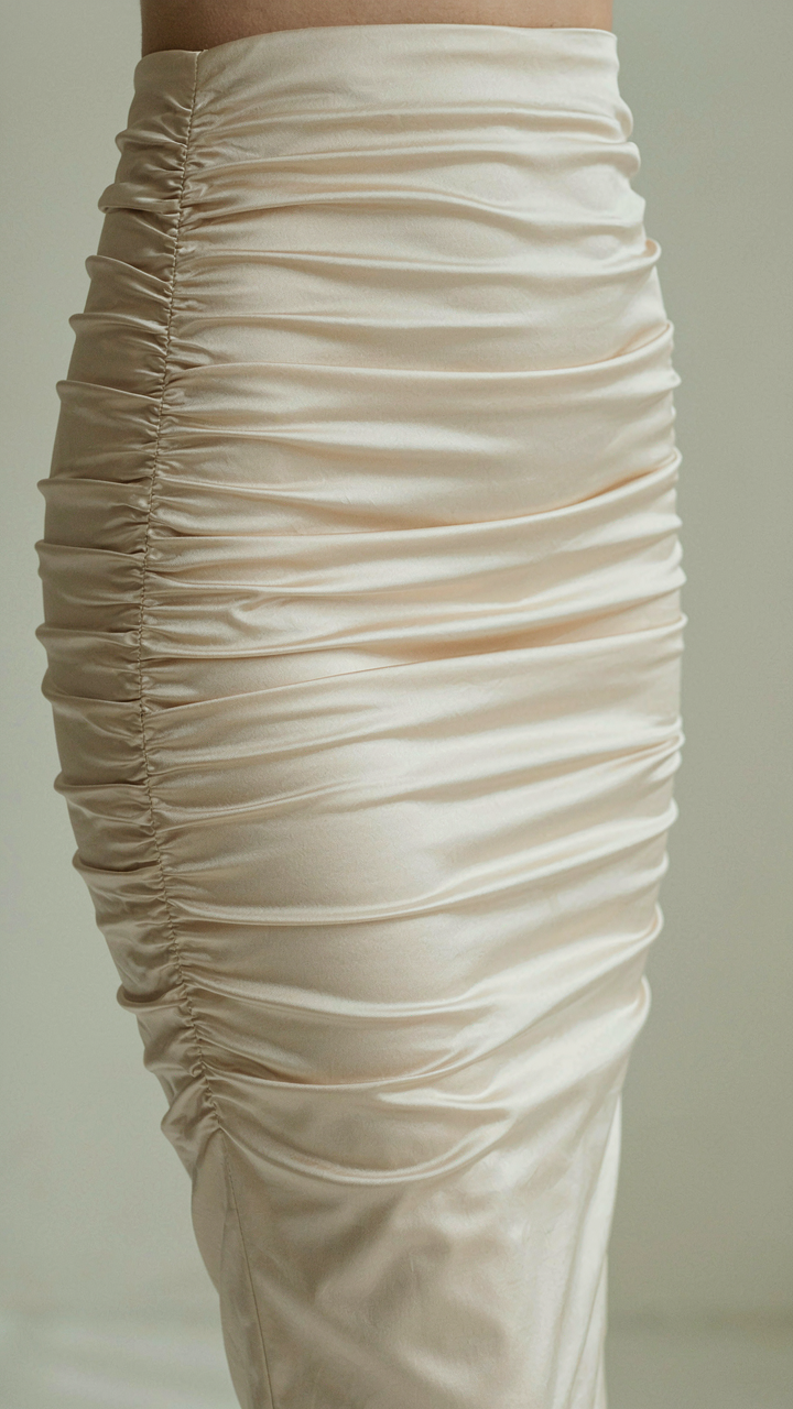 Close up of ruched fabric on a knee-length bodycon dress.