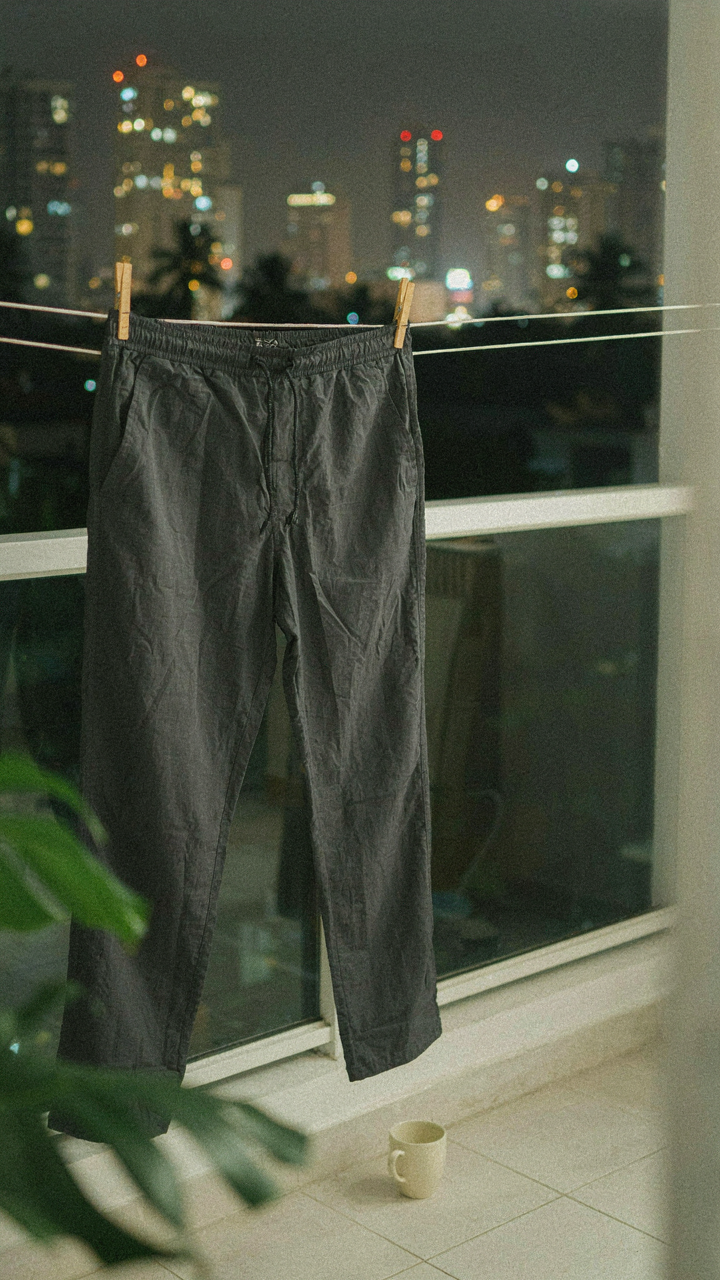 Quick-dry synthetic pants hanging on a clothesline on a hotel balcony.